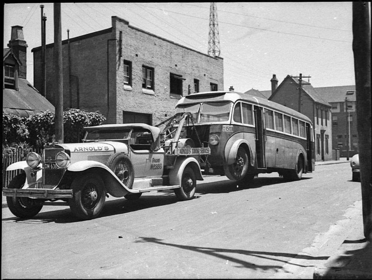 Flatbed tow truck safely transporting a disabled vehicle